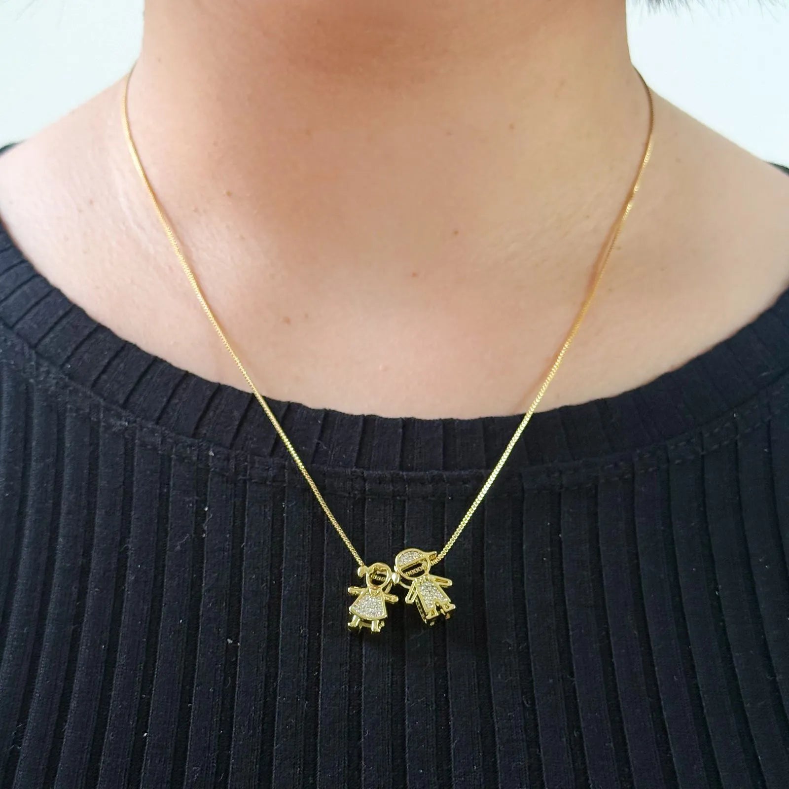 Modelo usando colar com casal de filhos dourado - joia simbólica Auri Joias