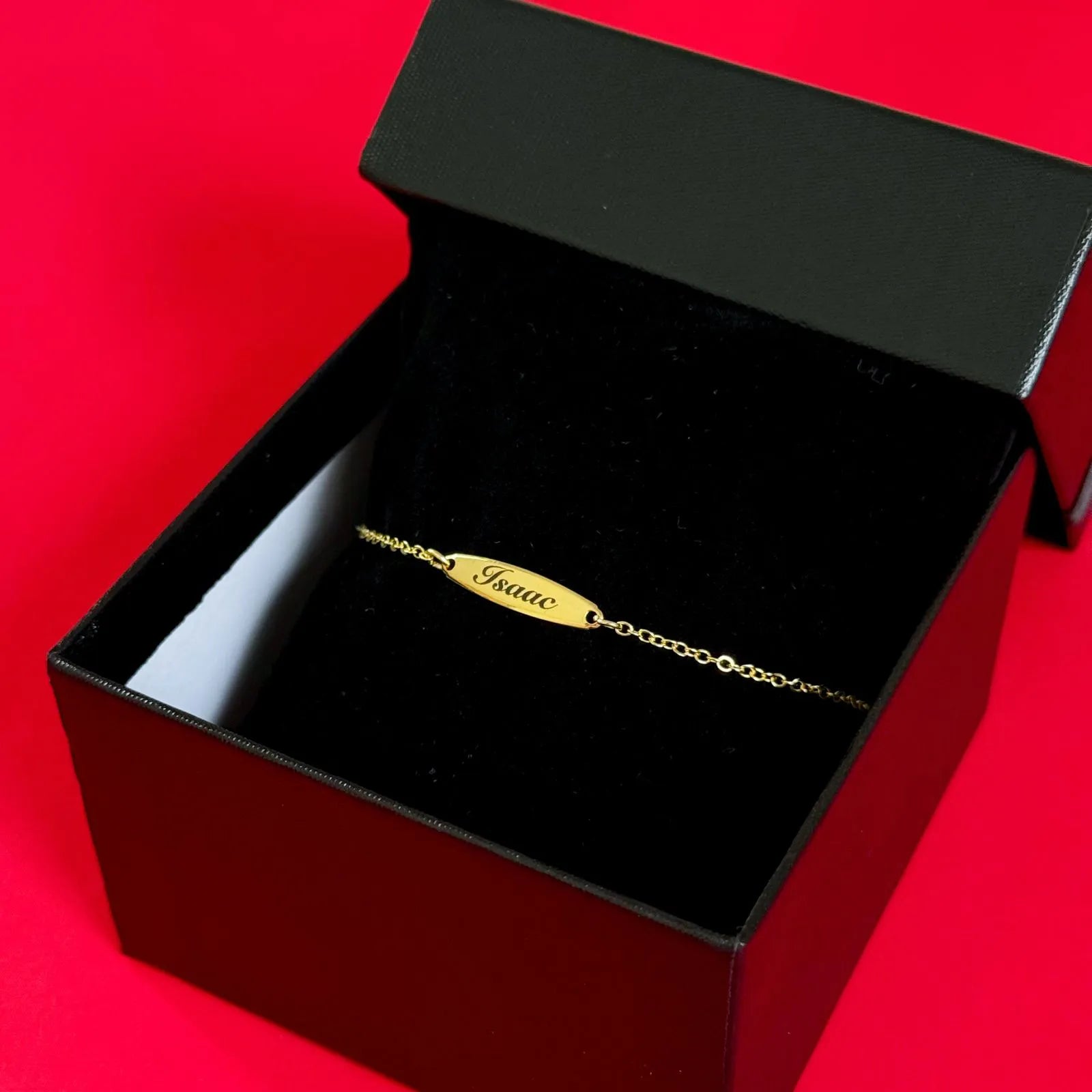 Pulseira Baby Oval dourada com placa para gravação, apresentada em caixa